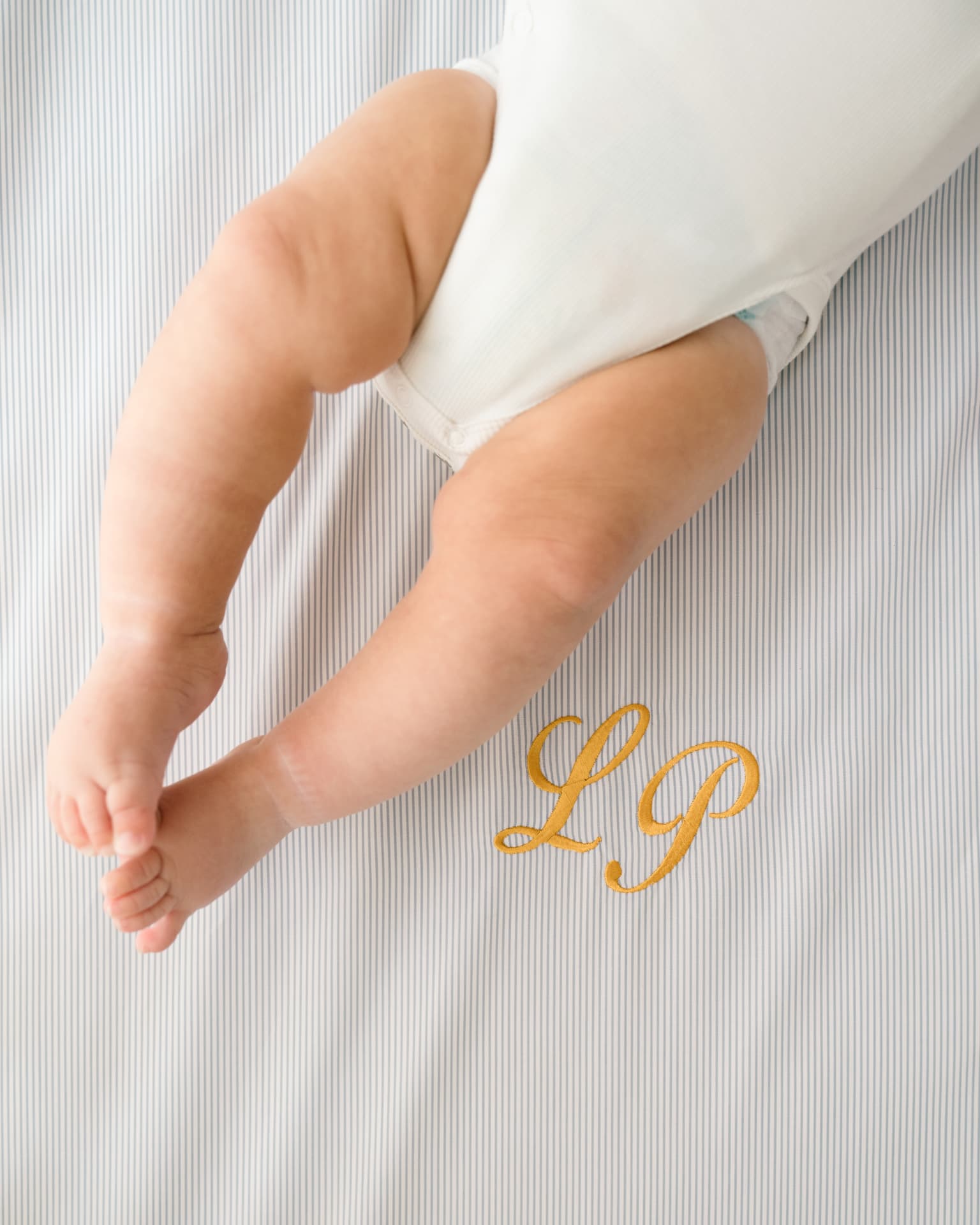 Baby feet resting on a Leaf fitted sheet